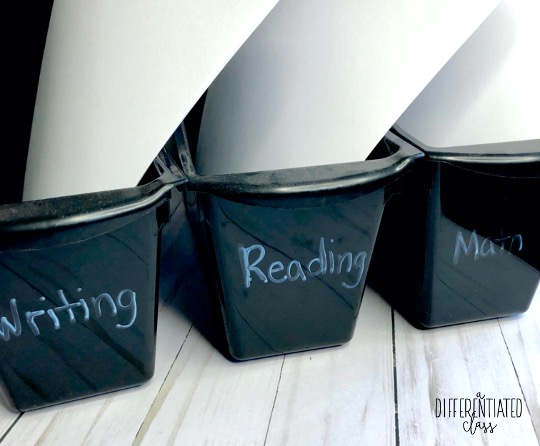 3 black book bins labeled writing, reading and math